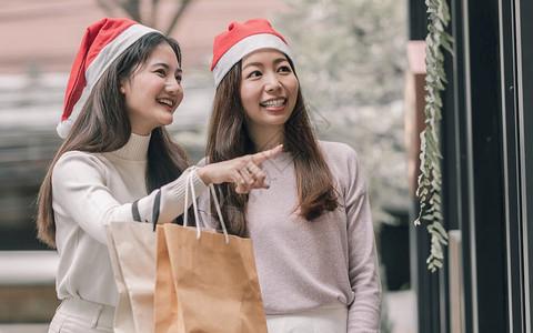 小百货店在圣诞节新年庆典和销售折扣概念中两个可爱的妇女在百货店买
